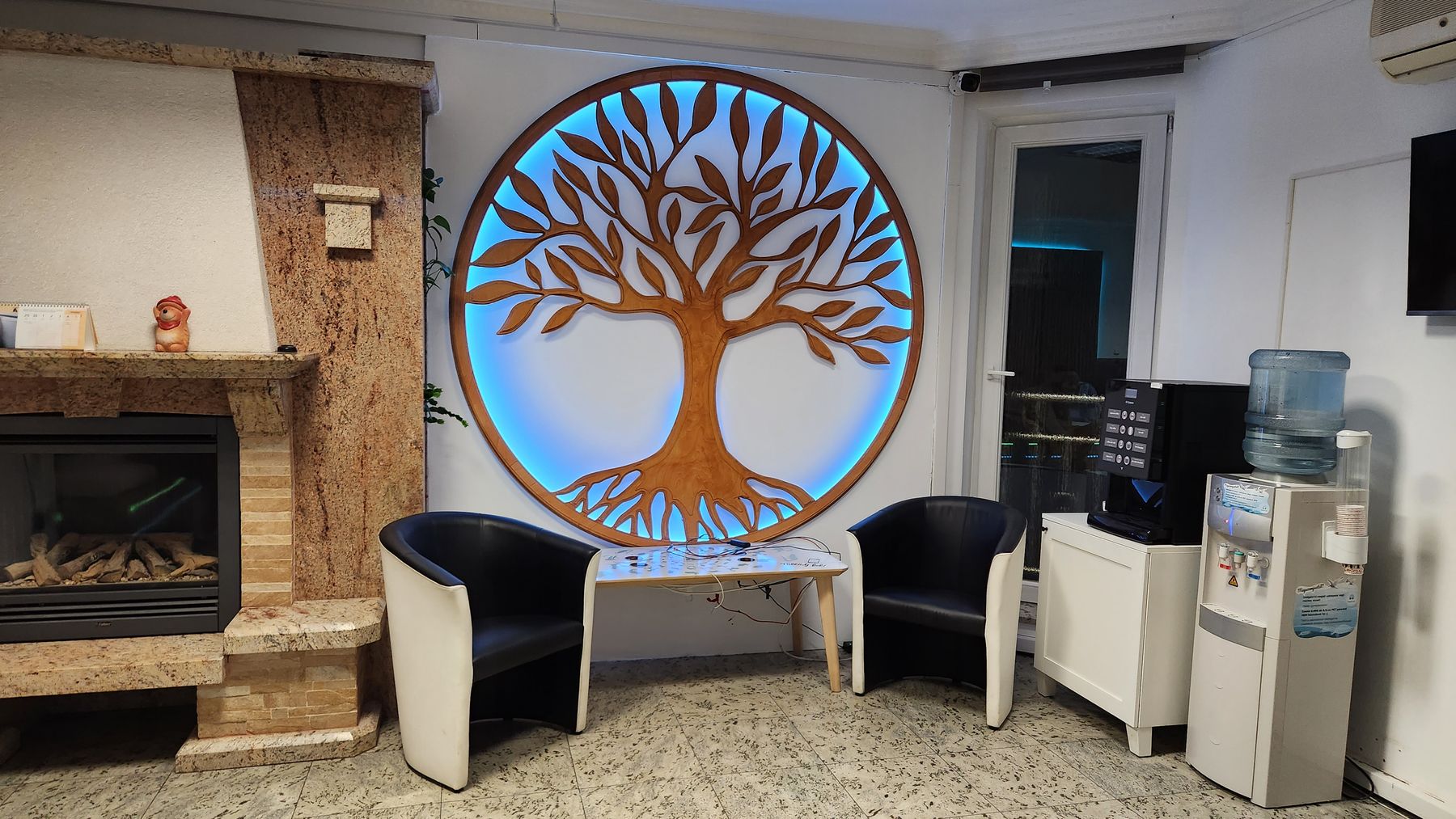 Warm, comfortable hospital lounge with fireplace, coffee machine and water dispenser